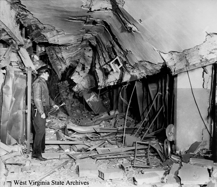 Osage police chief Clark Morris examining wrecked interior of bombed Osage Junior High School, Monongalia County, November 10, 1958. Archives Collection, West Virginia State Archives (339115)