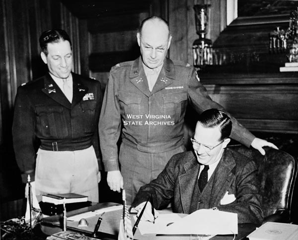 Governor Meadows signing Army Day proclamation, with Lt. Col. George
Rochman and Col. Nelson Diggley III.