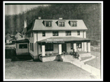 Exterior view of the two-story clubhouse at Coalwood with people on the steps.