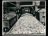 Loading booms (N&W cars) at mine Number 254. Man is standing on coal in car.