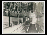 Interior of the African American section of the bath house at mine Number 251, showing wooden bench seating and bathing apparatus above.