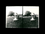 Young child (Martha) in wagon in yard at "Holmefield." Fence is in the background. Stereo.