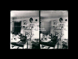 Interior view showing the first parlor of the Fred Ravens at Nuttalburg. View of table, fireplace and other furnishings. Stereo.