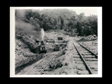 Surge basin site during the hydroelectric power construction on the New River. Continuation of tunnel adit cut. Shovel is completing the stripping of earth above rock. Rock is exposed at far end of cut. New-Kanawha Power Company, Hawks Nest - Gauley Junction Development No. 112.