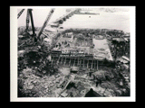 Dam site during the hydroelectric power construction on the New River. View shows dam excavation and two partially concreted blocks Nos. 28 and 29 of the dam on west side of river. Men working. New-Kanawha Power Company, Hawks Nest - Gauley Junction Development No. 234.