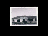 View of lumber stacked in the lumber yard at the Meadow River Lumber Company. From small red photo album.